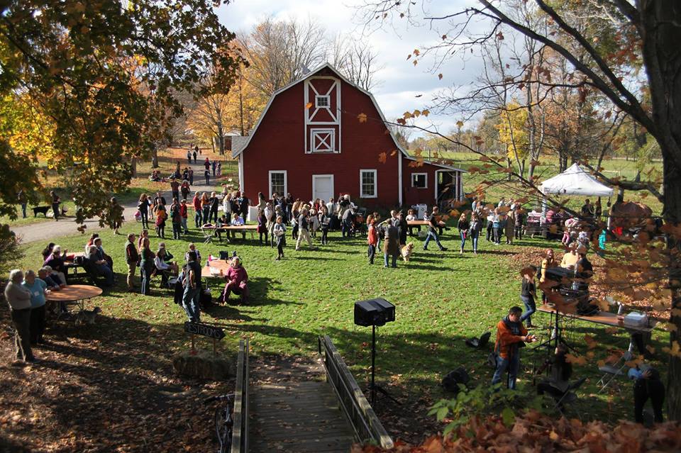 red barn  in background with people at festival in foreground