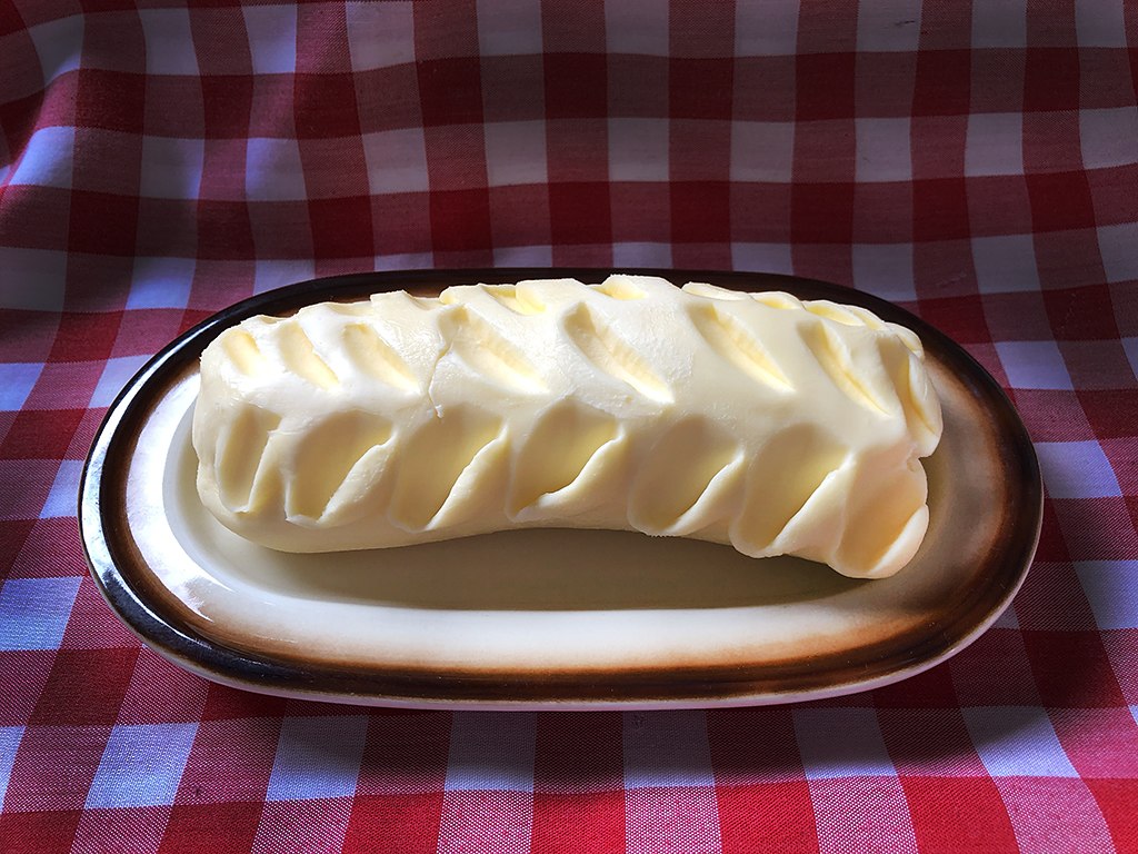 stick of butter on dish on red plaid tablecloth