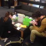 students working on gratitude journals in library 