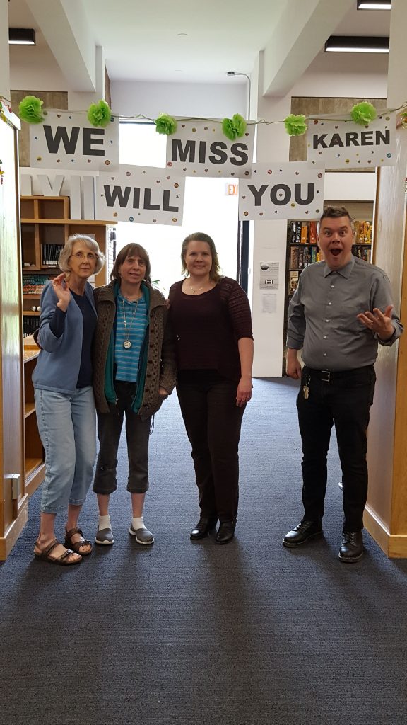 Karen with colleagues under the "We Will Miss You" sign! 
