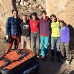 Earl and students pose in front of a rocky background