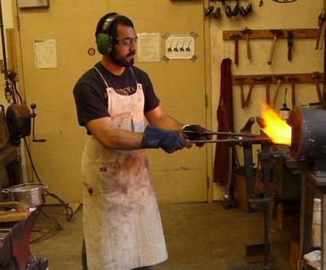 Student working at blacksmith forge