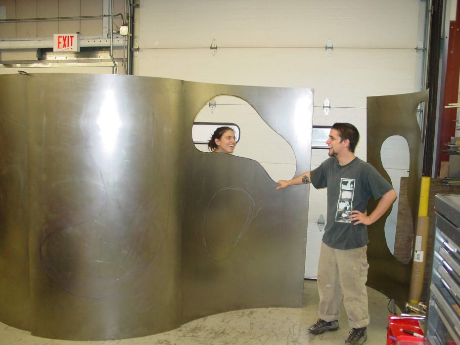 Students with large metal installation piece