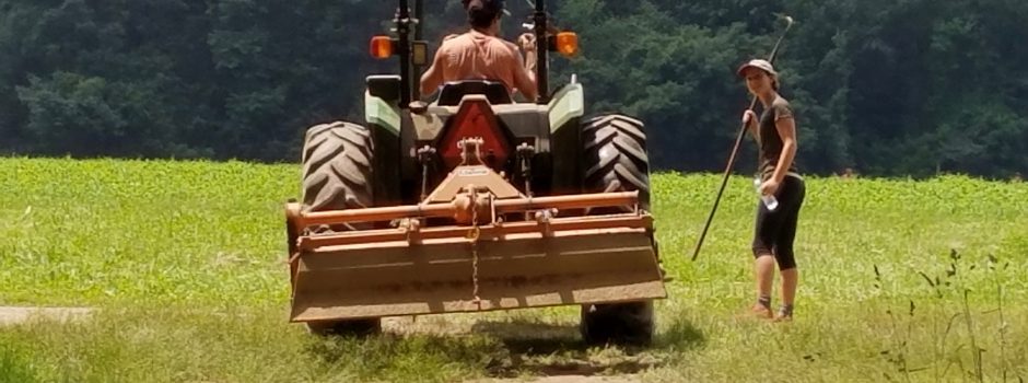 farmer on tractor next to student with hoe