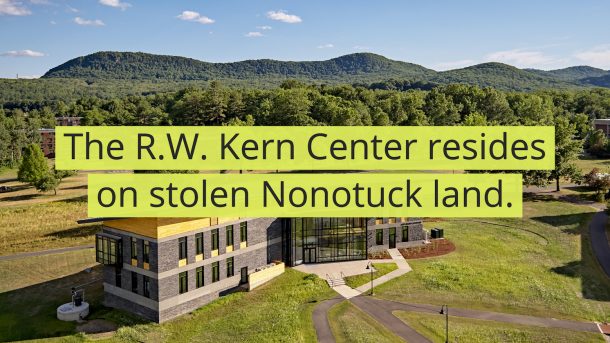 A drone photo of the R.W. Kern Center far away. There are black words on top of a yellow-green background that reads, "The R.W. Kern Center resides on stolen Nonotuck land."