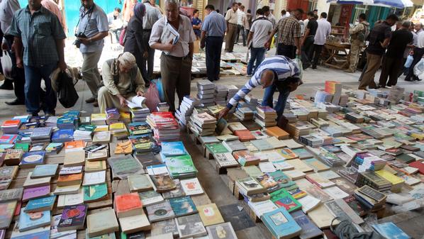 Iraqi men look at books at a second-hand