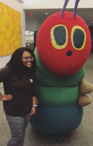 Student posing with Very Hungry Caterpillar character