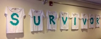 A display of T-shirts on a wall spelling out SURVIVOR