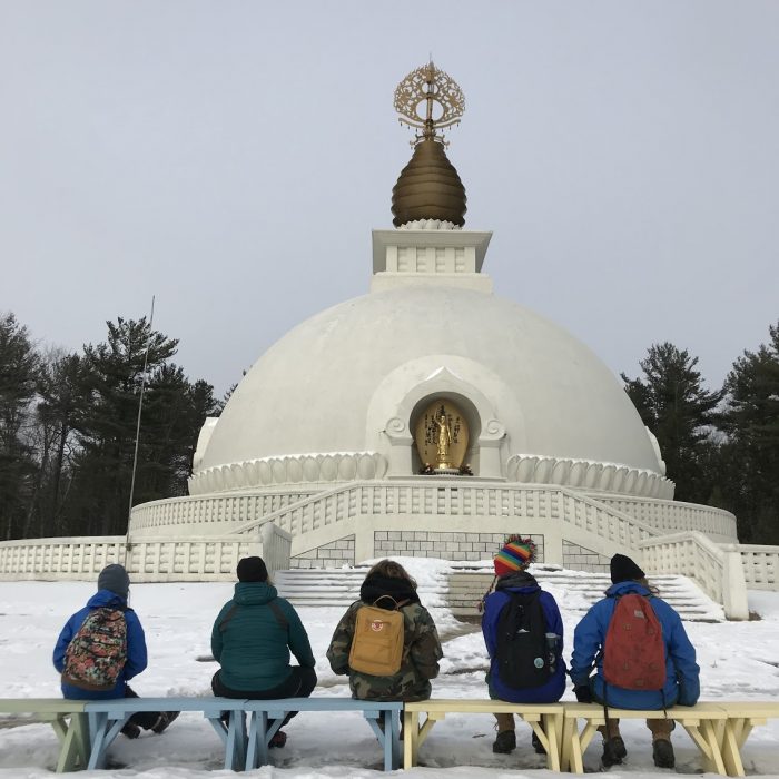 Students sitting on a bench in front of the Leverett Peace Pagoda