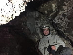 Student sitting inside a cave near ice