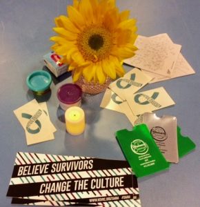 A table display for sexual assault activism month with cards that read Believe Survivors, Change The Culture